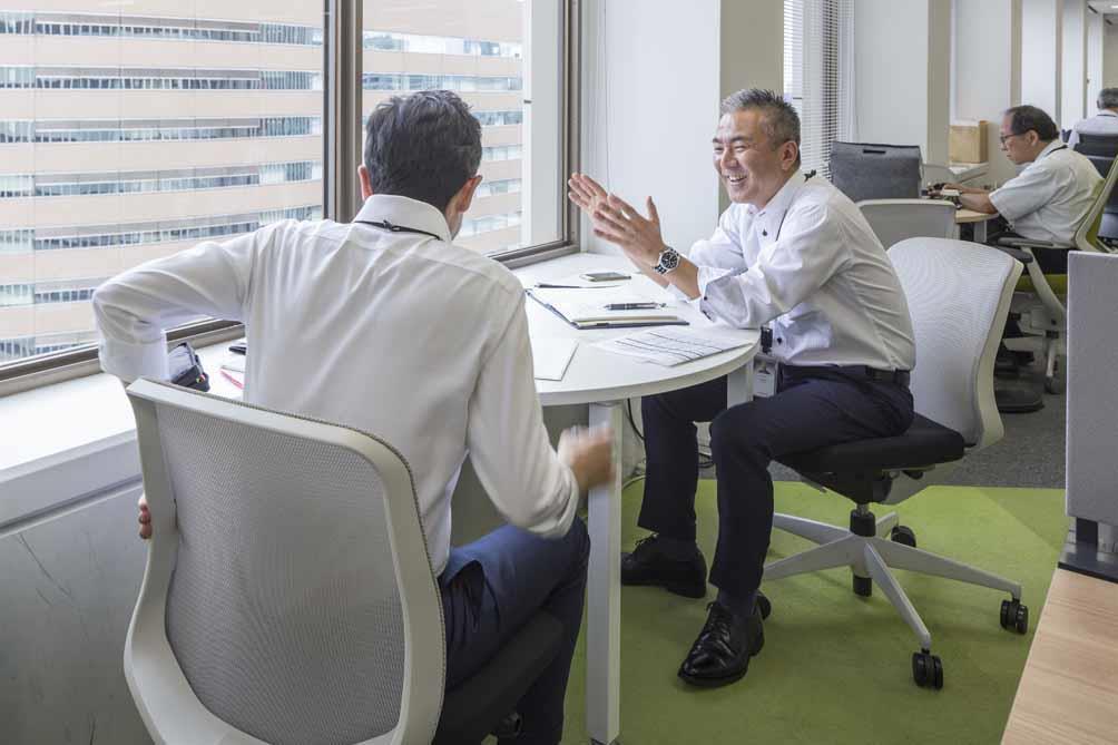 オフィスで楽しそうに談笑する男性