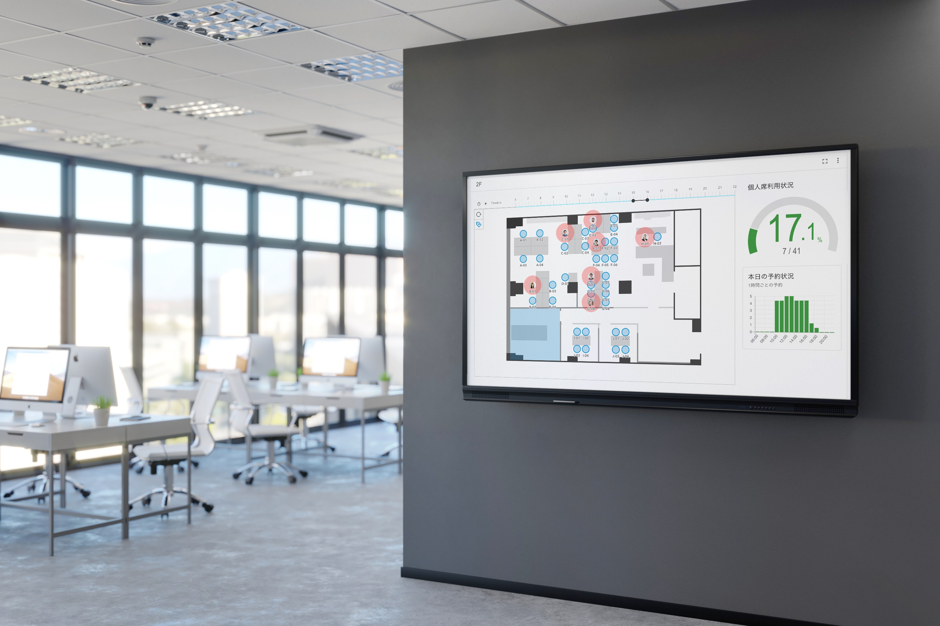 オフィスの壁面のモニターに座席管理システムが写っている