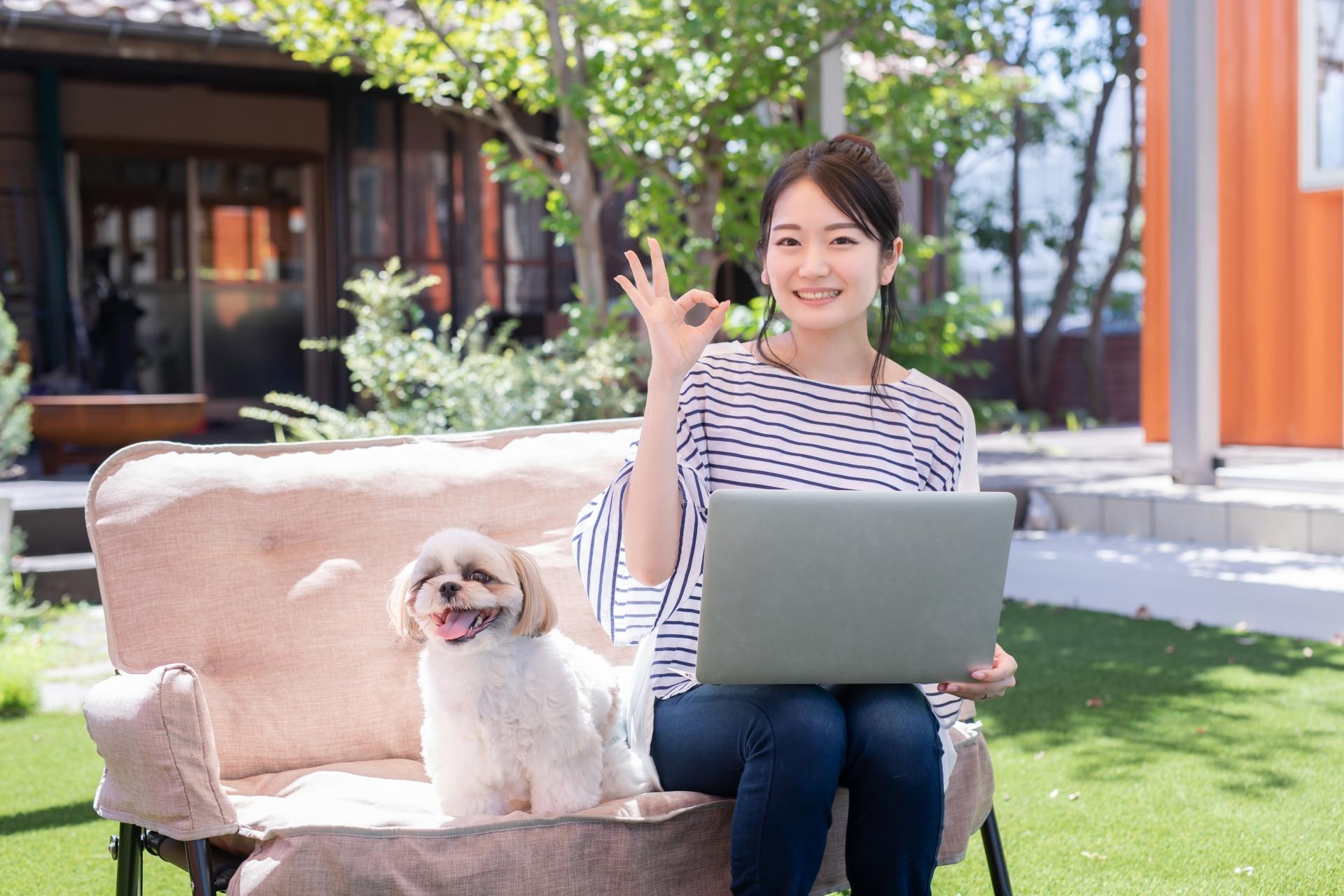 テラス席で犬と一緒にソファーに座っている女性