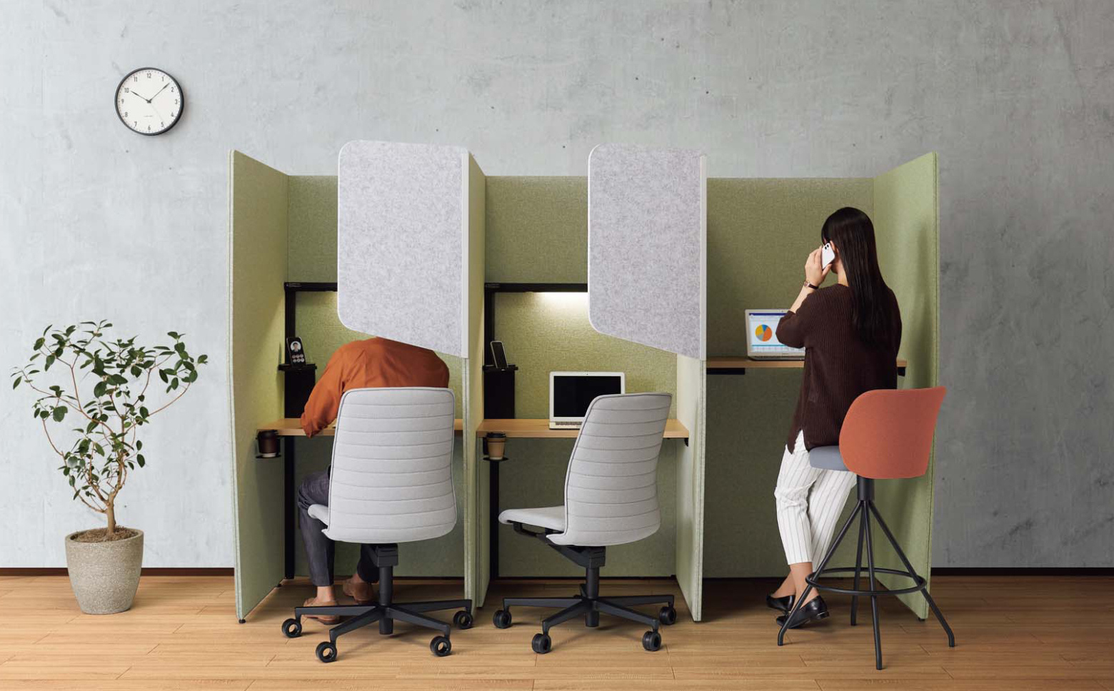 緑色のパネルで三面囲まれている簡易的な半個室ブースが3台並んでいるオフィス