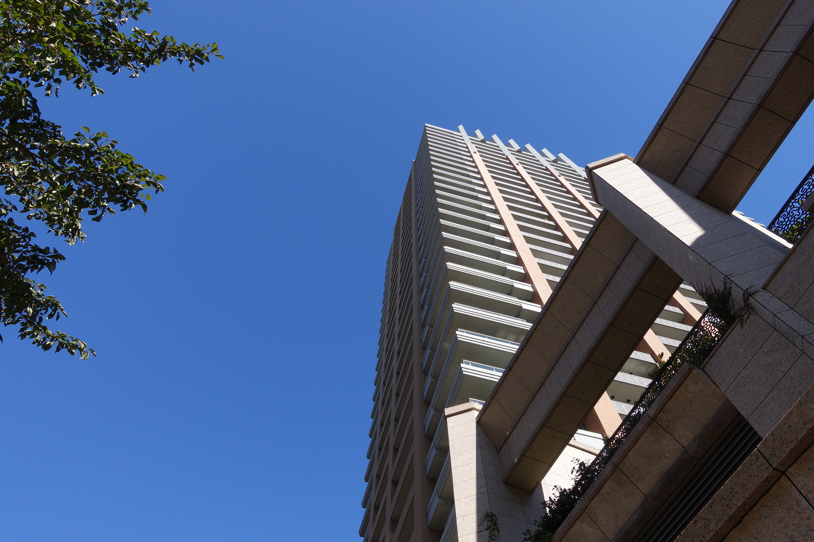 青空に向かって建っている高層マンション