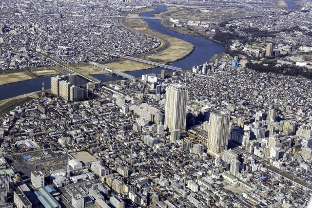 大きな川とところどころに高層ビルが建つ航空写真