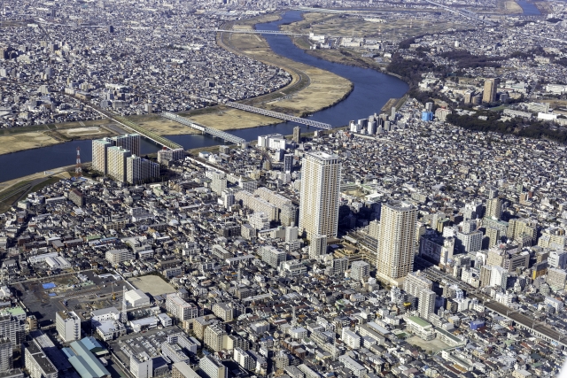 大きな川とところどころに高層ビルが建つ航空写真